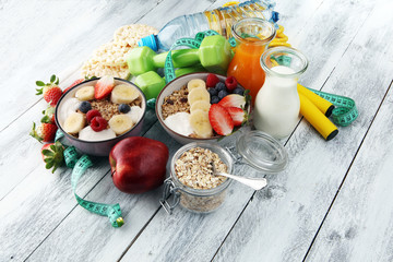 muesli with dairy and fruit, healthy lifestyle. bowl of cereal, fruit and dumbbell