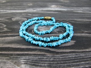Turquoise necklaces on wooden background