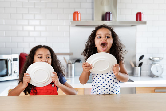 Little girls licking chocolate from plate