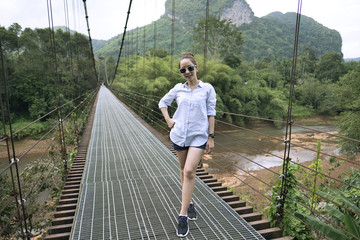 Naklejka premium traveler teen girl posing on the bridge and nature in weekend holiday
