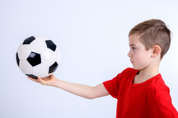 boy in red shirt with soccer ball