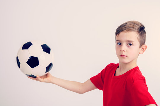 boy in red shirt with soccer ball
