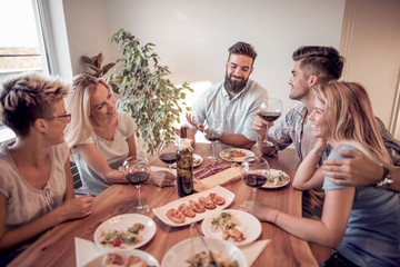 Group of  friends enjoying meal at home together
