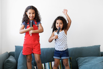 Little girls dancing on couch pretending to be pop stars