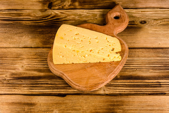 Cutting board with piece of cheese on a wooden table