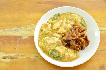 fried large rice noodles dressing with chicken and vegetable in gravy sauce on plate