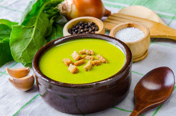 Spinach soup served on wooden board 