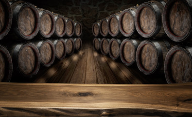 Old wooden table top and oak wine barrels at the background.