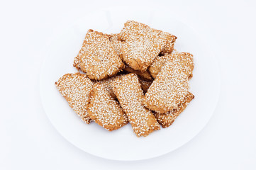 Homemade cookies with sesame seeds on a white plate.