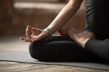  Young sporty woman practicing yoga, doing Padmasana exercise, Lotus pose, with mudra gesture, working out, wearing sportswear, black pants and top, indoor close up, yoga studio © fizkes