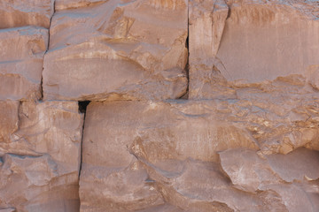 Old brown stone wall background, rough block texture.