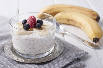 Smoothies with chia seeds and oat flakes with banana and frozen blueberries and raspberries