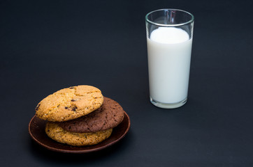 A variety of oatmeal cookies and a glass of milk.