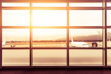 Fototapeta na wymiar Airport window side at departure with flare sunlight and airplane background,Toned color photo
