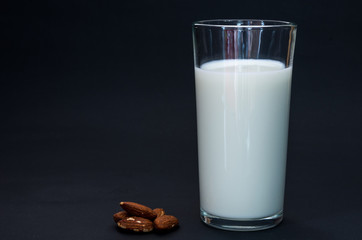 Almond milk on a dark background. Vegetarian milk.