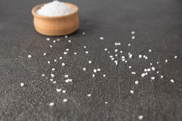 Crystals of salt on a dark cement background.