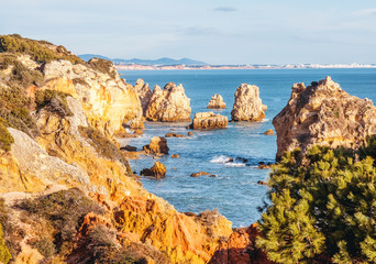 Fototapeta na wymiar Beautiful rocky coast of the ocean, stunning beautiful landscape of the Algarve, Portugal, waves crash against the shore in splashes, travel to Europe