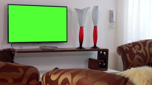 A TV with a green screen in a luxurious living room