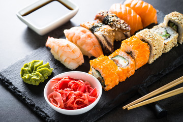 Sushi and sushi roll set on black stone table. © nadianb