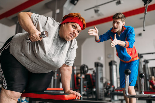 Fat woman makes selfie with instructor in gym