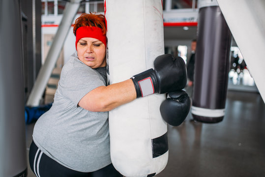 Overweight woman boxing exercise, punching bag