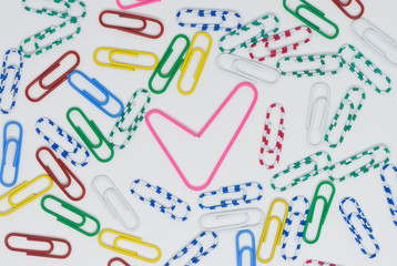 Valentine concept of pink paperclip like a heart among the colorful paperclip