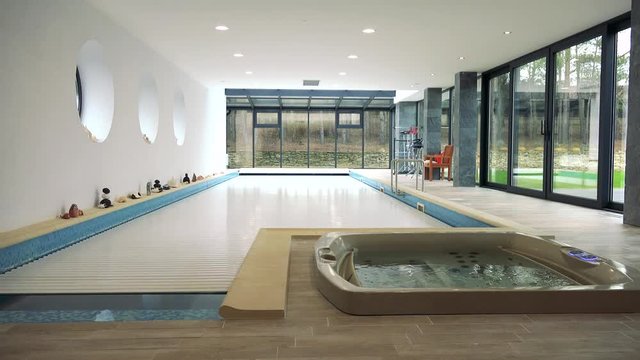 An automatic cover rolls over an indoor swimming pool - time-lapse