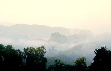 The view of layers of mountain in misty morning. fog is forming in the valley as the sun lighting up the day.