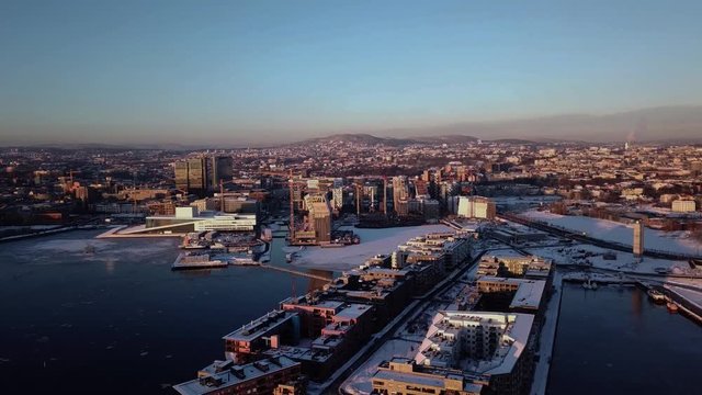 Aerial moving away shot of Opera and Lambda Munch museum in Oslo, Norway in winter