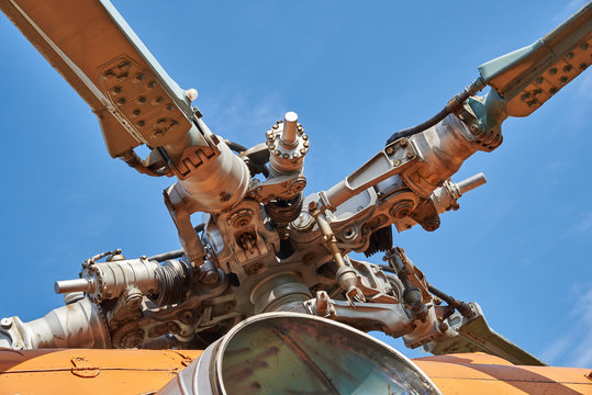 А swashplate of the rotor blades of the helicopter and exhaust pipe engine against the blue sky