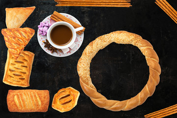 Cup of coffee and baked cake on black background