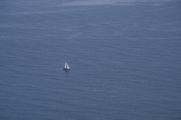 Lonely boat sailing at the open blue sea view from above