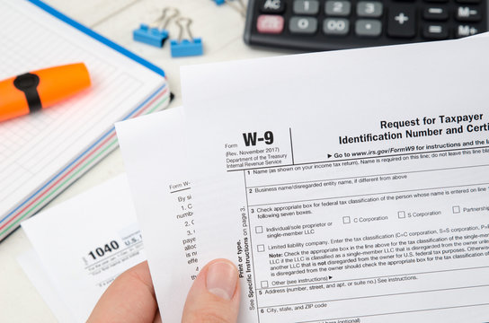 Man holding US tax form W-9