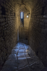 Stone interior with window of an old steeple crypt, located inside an ancient catholic church