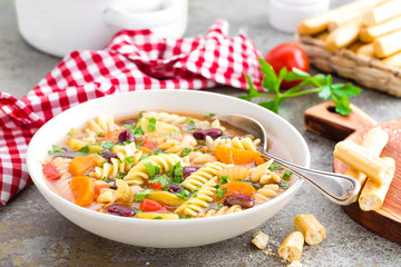 Minestrone soup. Vegetable soup with fresh tomato, celery, carrot, zucchini, onion, pepper, beans and pasta. Dish of italian cuisine.
