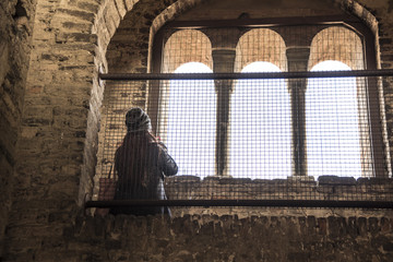 Fototapeta premium Europe travel woman looking throught big window of and old medieval steeple