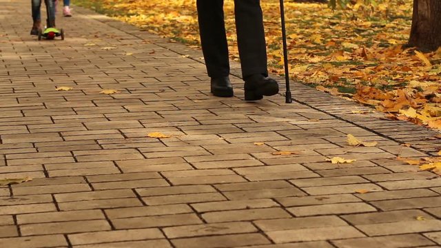 Lady walking in autumn park, holding cane. Recovery concept.  There is hope