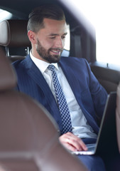 Portrait of a business man in the back seat of a car