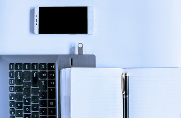 Laptop, pen, U disk, notebook and other office supplies on the table