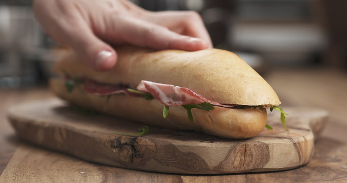 baguette sandwich with coppa and cream cheese on wood board