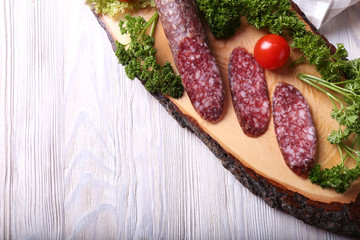 Salami sausages sliced on wooden board. Top view