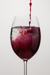 pour purple juice into still water in wine glass