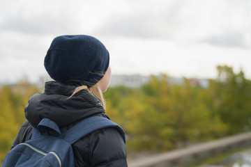 teen girl from behind walking in the city on a autumn day