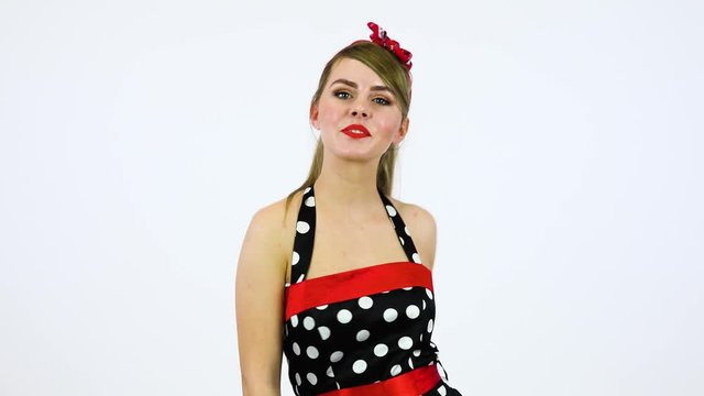 A beautiful 50s pin-up girl spins around, dances and smiles at the camera - white screen background