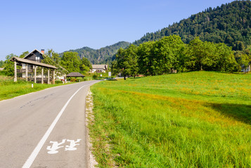 Pictorial field and an asphalt road on the background of mountain peaks, Bled, Slovenia.
