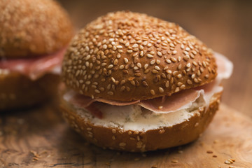 prosciutto and cream cheese in a sesame buns on wood board