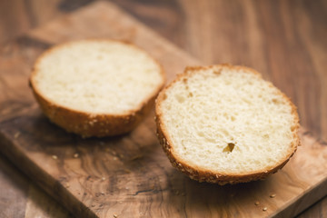 sliced sesame bun on wood board
