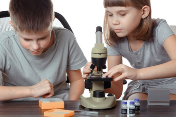 girl and boy teens with microscope isolated on white background