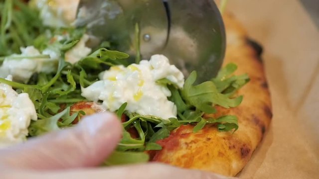 Chef cutting italian pizza with stracciatella