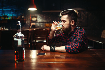 Man sitting at the bar and drink strong alcohol